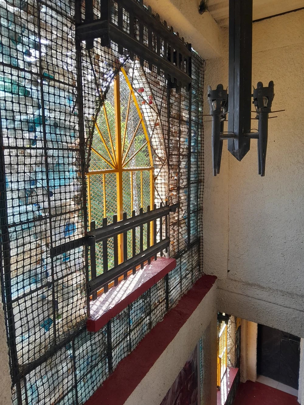 La estructura de cuatro pisos, reconocida por Guinness World Records, utiliza botellas plásticas como material de aislamiento y vitrales de colores (Créditos: plasticbottlevillage)