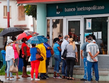 Varias personas hacen fila para entrar en un banco en La Habana (EFE/Yander Zamora)
