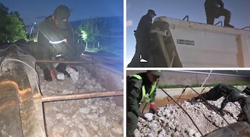 Oficiales en uniforme revisan la carga de un camión volquete blanco lleno de rocas de cuarzo durante una operación de control nocturno