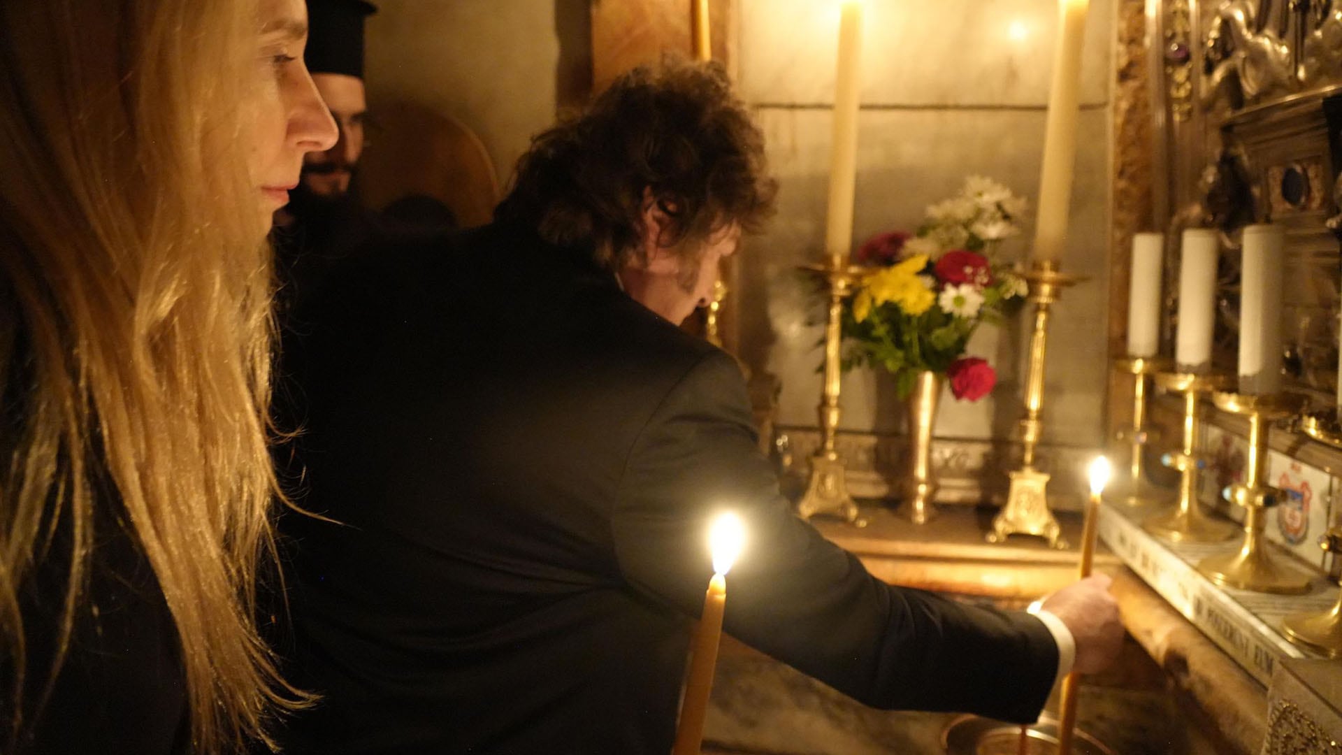 El presidente argentino Javier Milei en el Santo Sepulcro, encendiendo una vela durante su visita a Israel, acompañado por su hermana Karina Milei.