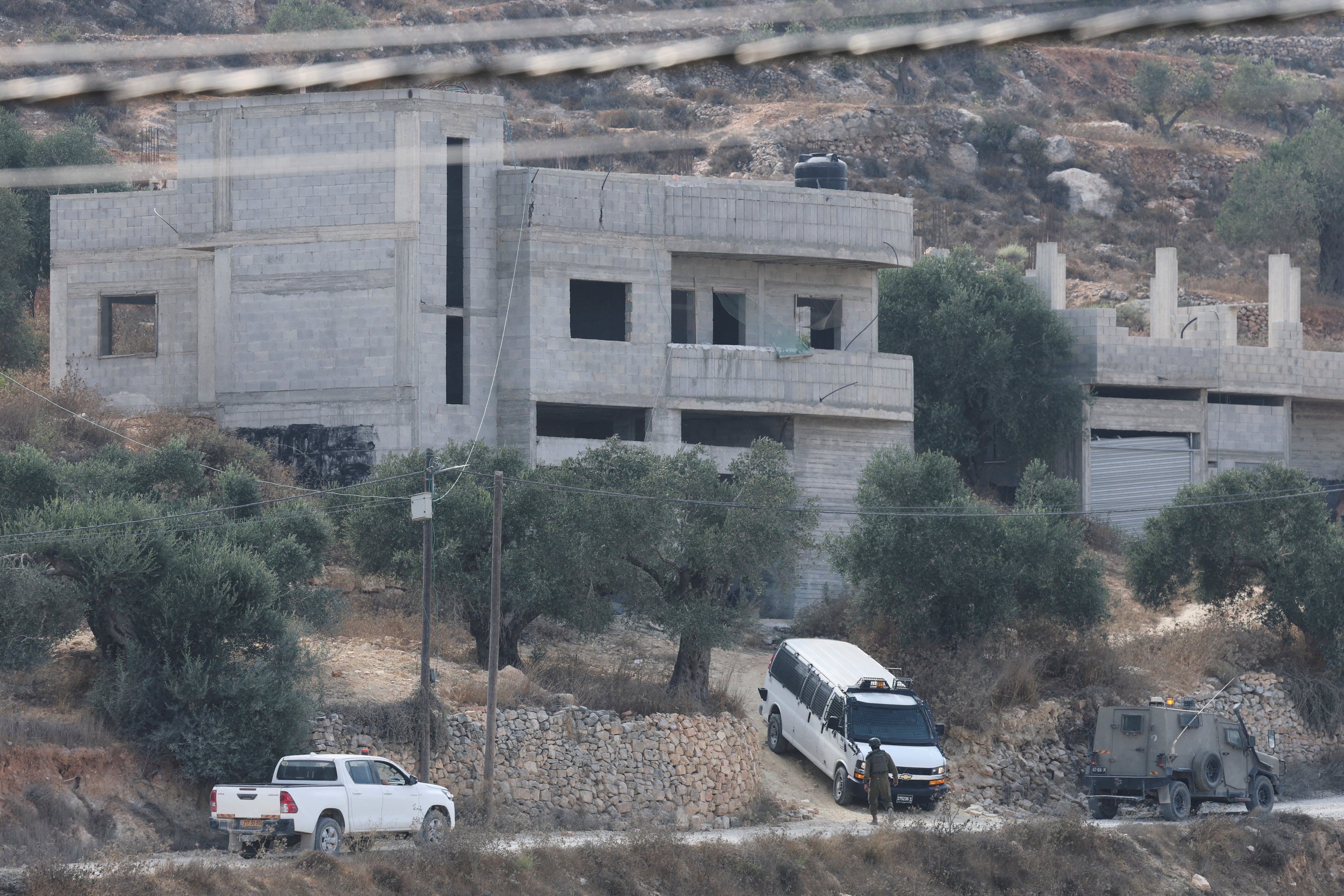 Militares israelíes cerca de una casa que fue atacada por colonos en la aldea palestina de Qusra, en Cisjordania. 29 agosto 2026. REUTERS/Ammar Awad