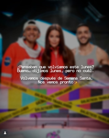 Tres presentadores borrosos, dos hombres y una mujer, sonríen frente a un fondo oscuro. Un texto anuncia su regreso aplazado. Cinta de precaución amarilla en primer plano