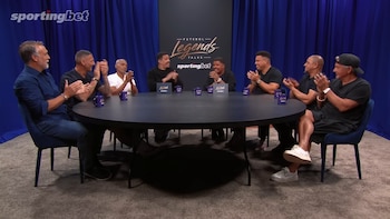 Seis hombres, Batistuta, Materazzi, Romario, Roberto Carlos, Ronaldo Nazario y Baggio, sentados alrededor de una mesa negra, aplauden. Fondo azul con logo Sportingbet