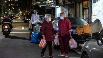 Los vecinos conversan mientras esperan