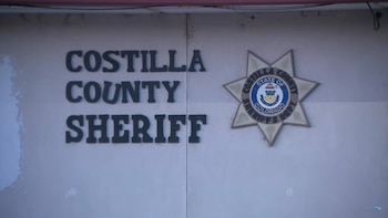 Un letrero que dice "COSTILLA COUNTY SHERIFF" junto a un emblema estrellado del departamento del sheriff de Costilla, Colorado