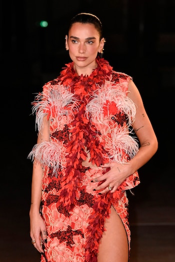 Dua Lipa lució un vestido corto en tonos coral y rosa salmón con aplicaciones de plumas y bordados (Grosby)