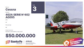 Avioneta Cessna 402A blanca, roja y azul sobre pasto con dos hélices frontales. A la izquierda, datos de la subasta como marca, modelo y precio