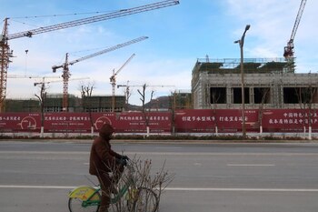Un hombre monta una bicicleta frente a un proyecto inmobiliario del grupo Yango en construcción en la Nueva Zona de Yanan, provincia de Shaanxi, China (REUTERS/Yawen Chen)