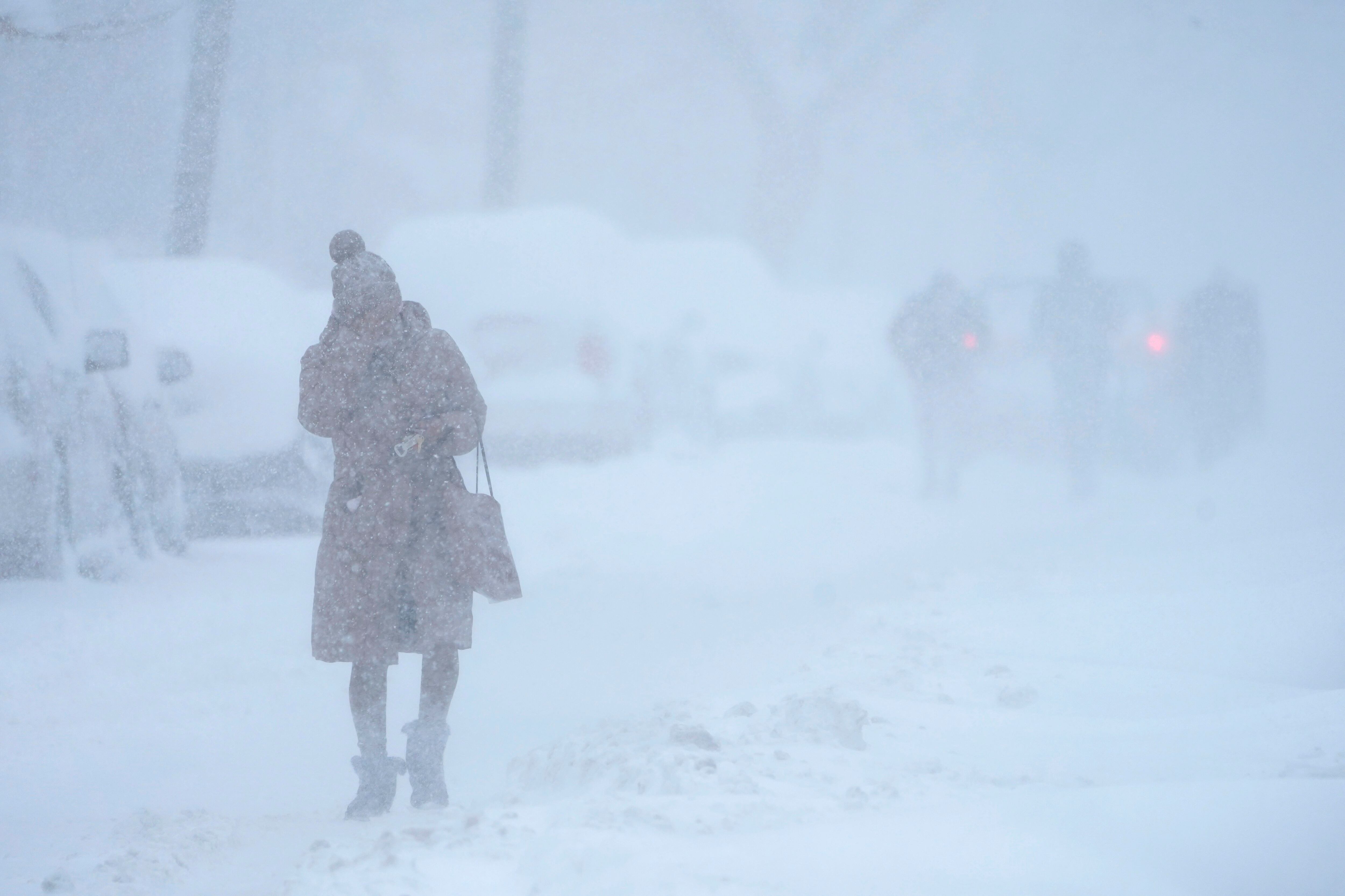 Una mujer se protege el rostro de la nieve mientras camina en medio de una tormenta en Jersey City, Nueva Jersey, el lunes 1 de febrero de 2021. Una extensa tormenta invernal afectó el este de EE.UU. (ARCHIVO/AP/Seth Wenig)