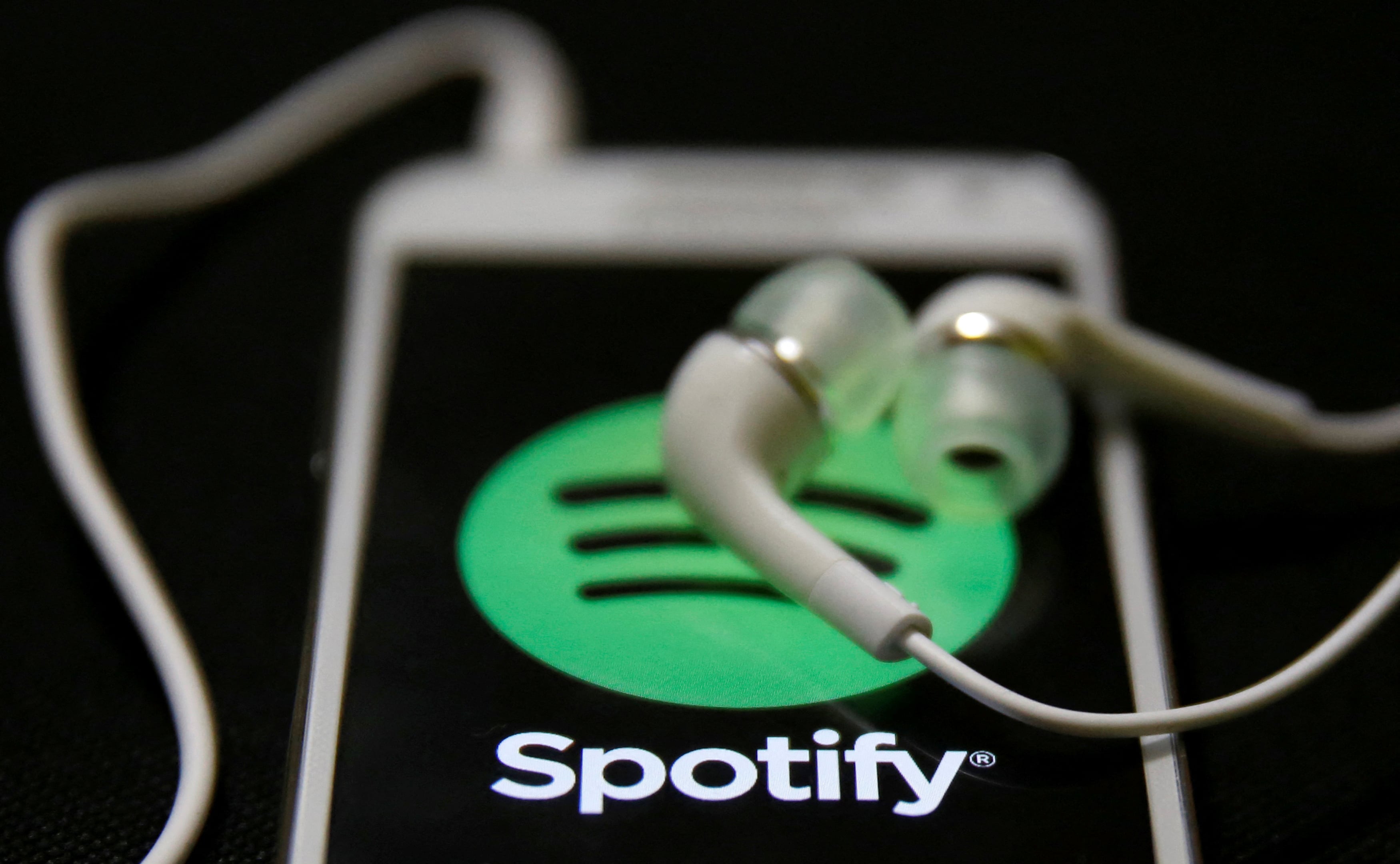 FILE PHOTO: Earphones are seen on top of a smart phone with a Spotify logo on it, in Zenica February 20, 2014. REUTERS/Dado Ruvic/File Photo