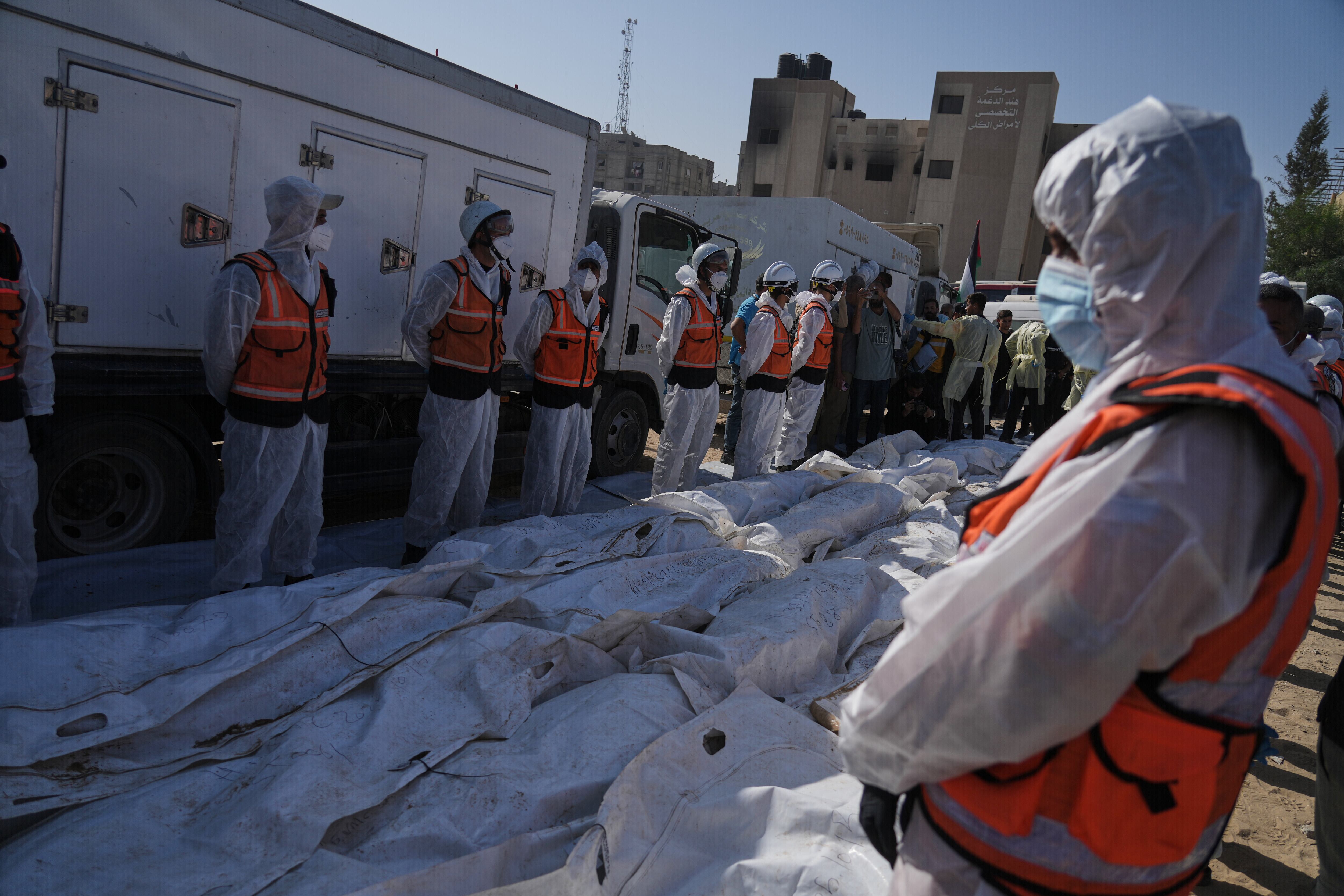 Los restos de palestinos no identificados, devueltos por Israel como parte de un acuerdo de alto el fuego, son preparados para un funeral multitudinario frente al Hospital Nasser en Jan Yunis, en la Franja de Gaza, el miércoles 22 de octubre de 2025 (Foto AP/Jehad Alshrafi)