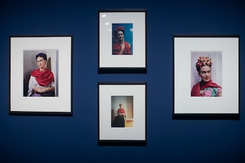 Cuatro fotografías enmarcadas de Frida Kahlo vestida con rebozo rojo, colocadas sobre una pared azul