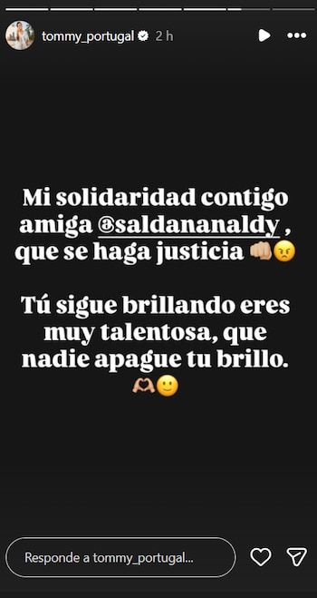 Mensaje de texto blanco sobre pantalla oscura de Tommy Portugal a Naldy Saldaña. Emojis de puño, cara enojada, manos de corazón, cara sonriente