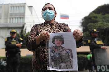 Una mujer sostiene una fotografía durante un plantón frente a la embajada de Rusia este martes, en Lima (Perú). EFE/ Paolo Aguilar