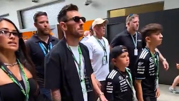 La familia Messi, con Antonela Roccuzzo y Lionel Messi con gafas de sol, junto a sus hijos, observan atentamente un evento en el GP de Miami de F1