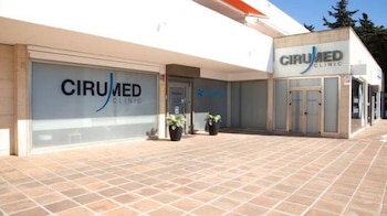Fachada exterior de un establecimiento con letreros de Cirumed Clinic y puertas de vidrio sobre un suelo de baldosas
