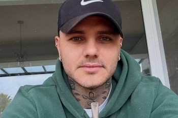 Retrato en primer plano de Mauro Icardi con gorra negra, sudadera verde, tatuajes en el cuello y la bombilla de un mate