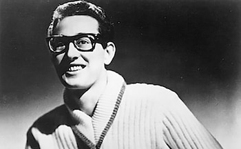 Retrato en blanco y negro de un hombre joven con gafas de montura negra y un jersey claro de cuello trenzado