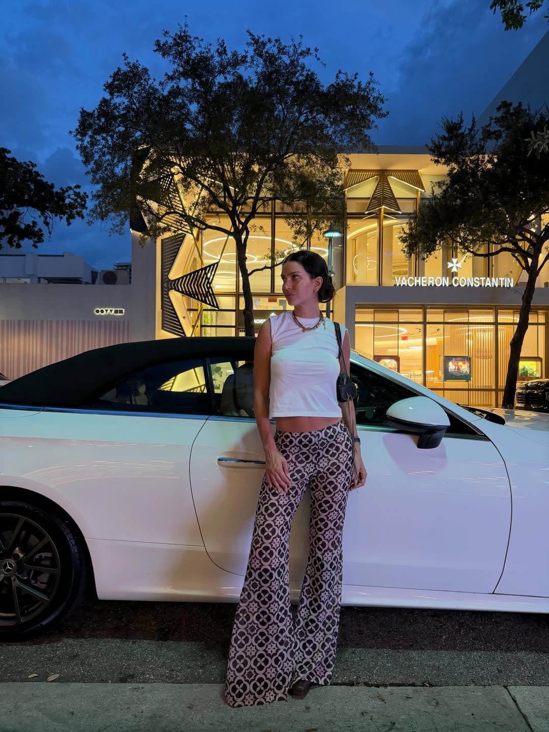 Nara posó con un look casual y elegante junto a un convertible blanco en una calle iluminada de Miami, frente a una lujosa boutique de relojes