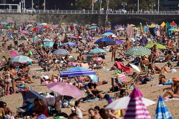 Bañistas toman el sol en
