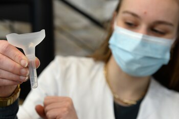 A pharmacist displays a COVID-19 saliva self-test kit in a drugstore in Brussels amid the coronavirus disease (COVID-19) outbreak in Belgium, April 6, 2021. REUTERS/Johanna Geron
