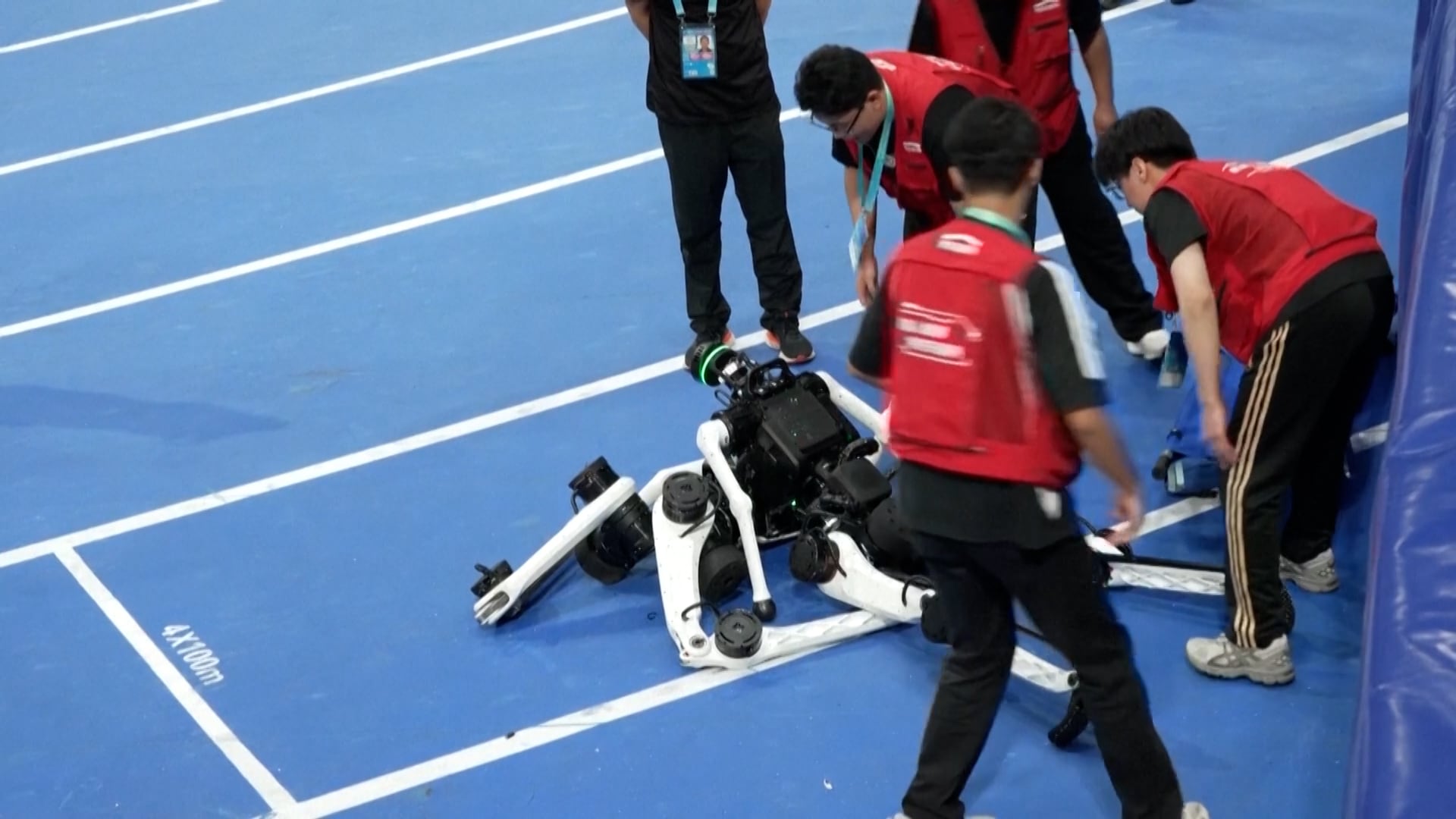 Asistentes trabajan en levantar los robots tras las carreras