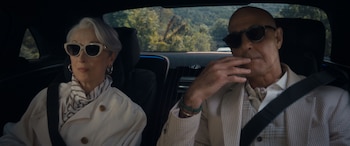 Miranda Priestly, interpretada por Meryl Streep, con gafas de sol claras, y Stanley Tucci, con gafas oscuras, sentados en un coche