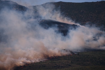 Un helicóptero de extinción de incendios arroja agua sobre las llamas mientras un incendio forestal avanza cerca de Burgohondo, en la provincia de Ávila, España, el viernes 24 de julio de 2026 (AP/Manu Fernandez)