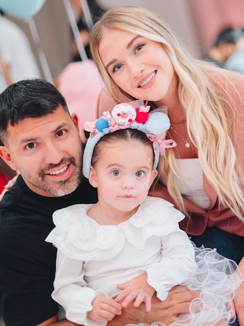 Sergio Agüero y Sofía Calzetti posan junto a una niña pequeña que lleva una vincha decorativa con adornos