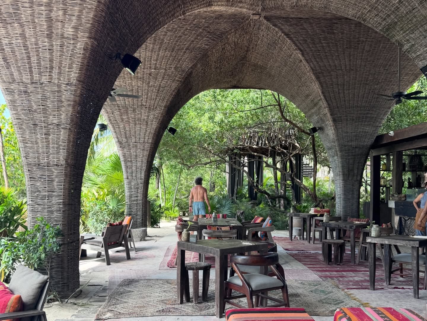 La arquitectura característica de los espacios gastronómicos de Holbox, con arcos de palma y vegetación