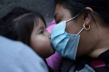 IMAGEN DE ARCHIVO. Una mujer migrante bes a su hija durante un encuentro para requerir al Gobierno chileno regularizar su estatus, en medio de la pandemia de coronavirus, en Santiago, Chile. Abril 12, 2021. REUTERS/Iván Alvarado/