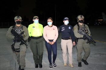 Efectivos de la Policía Nacional de Colombia escoltan a Nini Johana Úsuga, alias 'La Negra', hermana de 'Otoniel', máximo líder del grupo armado organizado Clan del Golfo, tras su detención en Sabaneta, Colombia, 18 de marzo, 2021. Policía Nacional de Colombia/via REUTERS ATENCIÓN EDITORES - ESTA IMAGEN FUE PROPORCIONADA POR UN TERCERO