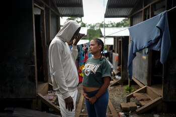 La migrante colombiana Georyeth Barreto, embarazada de seis meses, junto a su prometido Anthony Herrera mientras habla por teléfono en un campamento temporal después de haber cruzado el Tapón del Darién (Foto AP/Matías Delacroix)