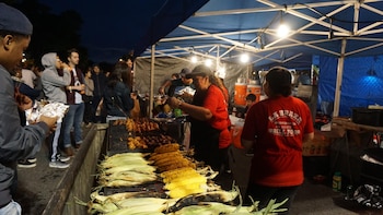 Puestos de comida reciben a visitantes y residentes durante un evento cultural nocturno, reflejando el impacto económico que generan los conciertos y festivales en los barrios de la ciudad.