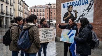 Cinco mujeres, periodistas nicaragüenses exiliadas, en una calle. Una sostiene una pancarta, otra un mapa y bandera de Nicaragua, frente a un mural con "Nicaragua".