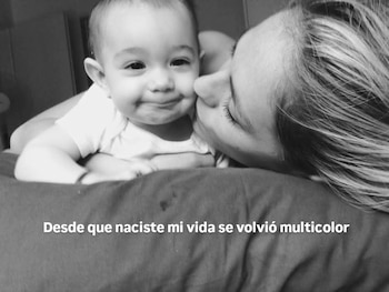 Fotografía en blanco y negro de Rocío Igarzábal besando la mejilla de su hija bebé, Lupe, que sonríe a la cámara