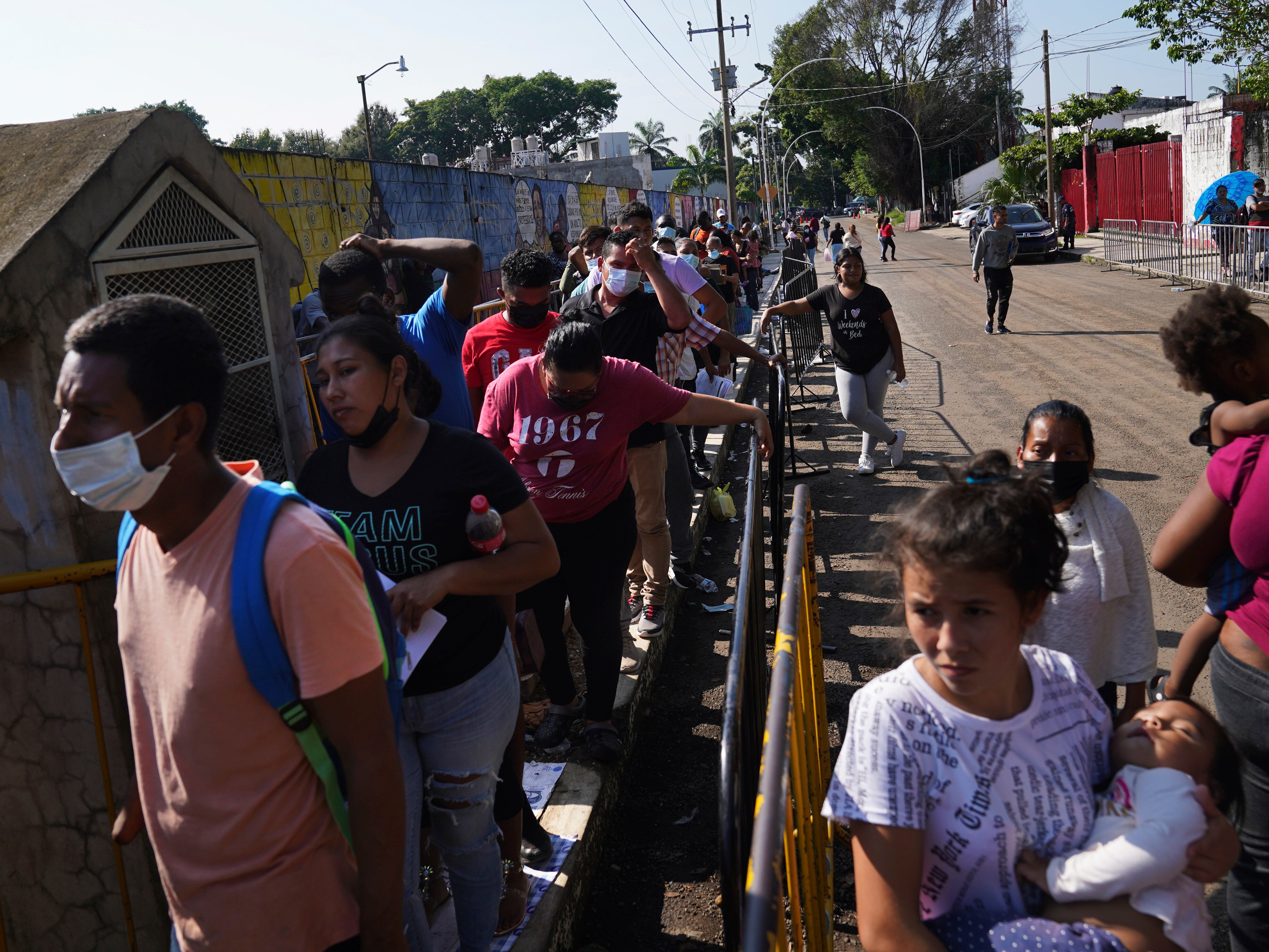Migrantes esperan su turno para solicitar documentos migratorios frente al Instituto Nacional de Migración en Tapachula, estado de Chiapas, México, el martes 4 de octubre de 2022. La estrategia de México durante el último año ha sido administrar el imparable número de llegadas facilitando ciertos permisos sin criterios claros. (AP Foto/Marco Ugarte)
