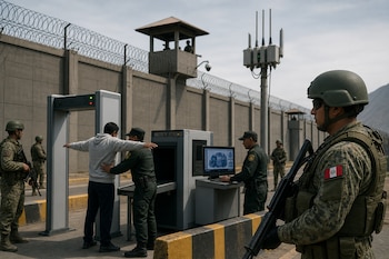 Militares resguardan un control de acceso con arco detector de metales, escáner de bultos y torre de vigilancia al fondo.