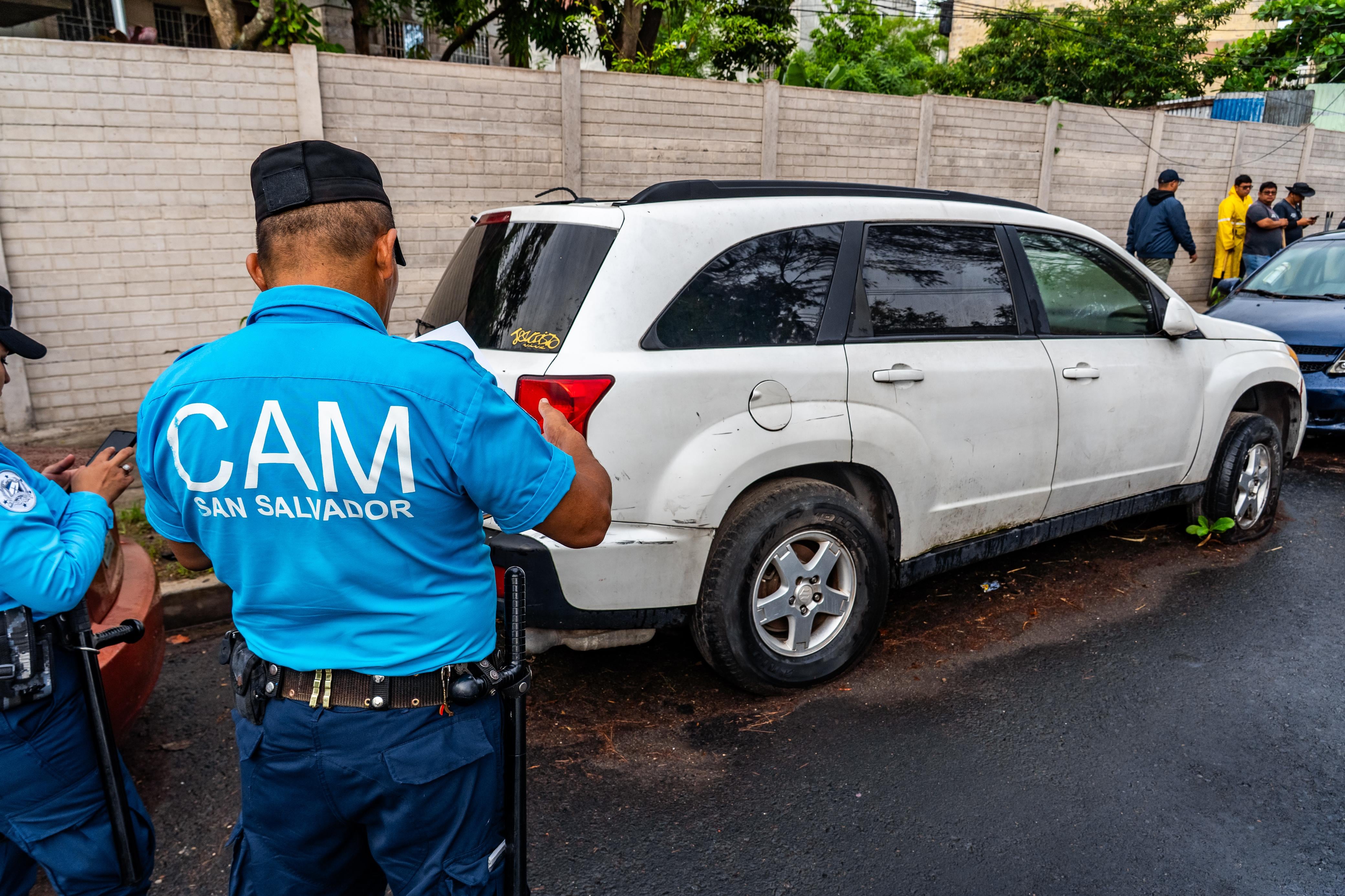 Agentes del Cuerpo de Agentes Metropolitanos (CAM) de San Salvador documentan el estado de un vehículo abandonado antes de su retiro (Cortesía Alcaldía de San Salvador Centro).