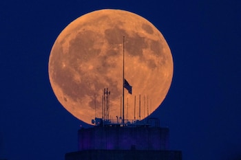 La luna llena sale detrás del ayuntamiento en el centro de Kansas City, Misuri, antes de un eclipse lunar el jueves 27 de agosto de 2026 (AP/Charlie Riedel)