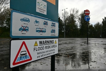 Un cartel de alerta por inundación junto al río Eden, en Carlisle, en el noroeste de Inglaterra, mientras la tormenta Boelo trae fuertes vientos y lluvias al norte del país. Hay alertas por inundaciones en la región (Andy Buchanan/AFP)