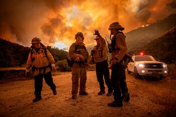 Bomberos conversan en medio de