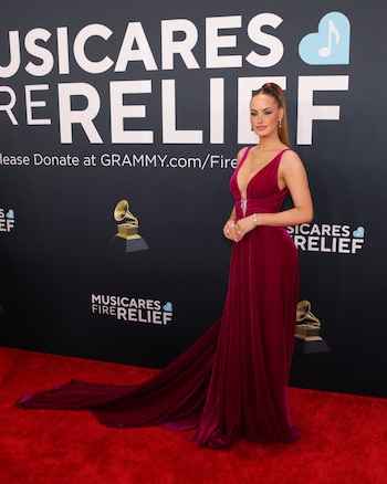 La modelo Haley Kalil y un vestido largo en tonos en rojo, de escote profundo y corte fluido con una cola que aportó elegancia al diseño