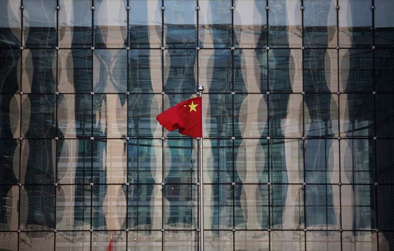 Una bandera china ondea en la sede de un banco comercial en una calle financiera cerca de la sede del Banco Popular de China, el banco central de China, en el centro de Beijing. REUTERS/Kim Kyung-Hoon