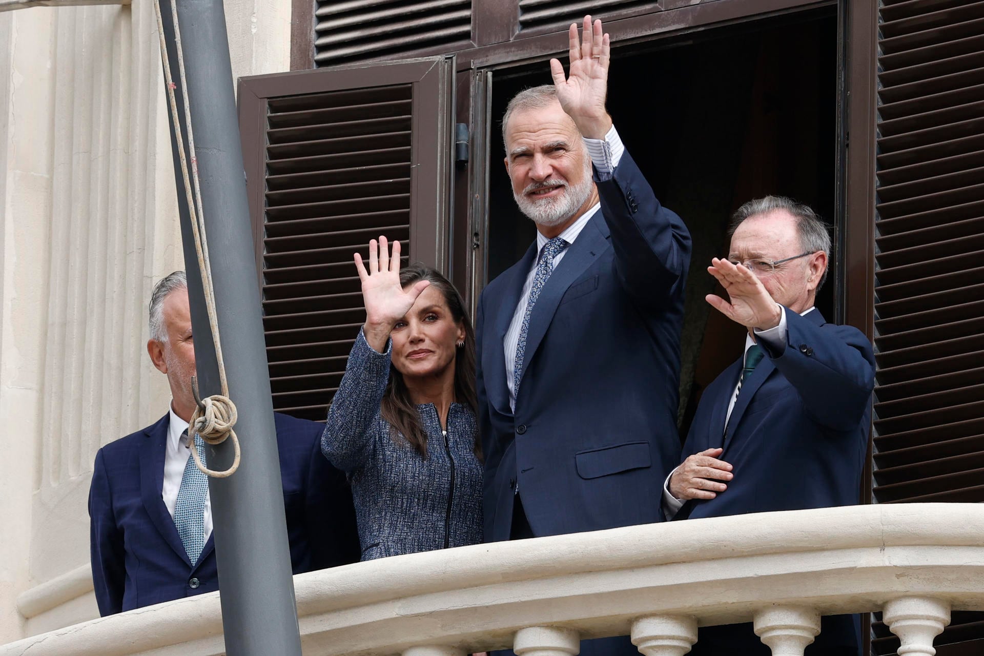 El rey Felipe VI (2d) y la reina Letizia (2i) saludan desde el balcón del Ayuntamiento junto al alcalde-presidente de la Ciudad Autónoma de Ceuta, Juan Jesús Vivas (d), y el ministro de Política Territorial y Memoria Democrática, Ángel Víctor Torres (i), a su llegada a Ceuta, este martes. (EFE/Chema Moya)