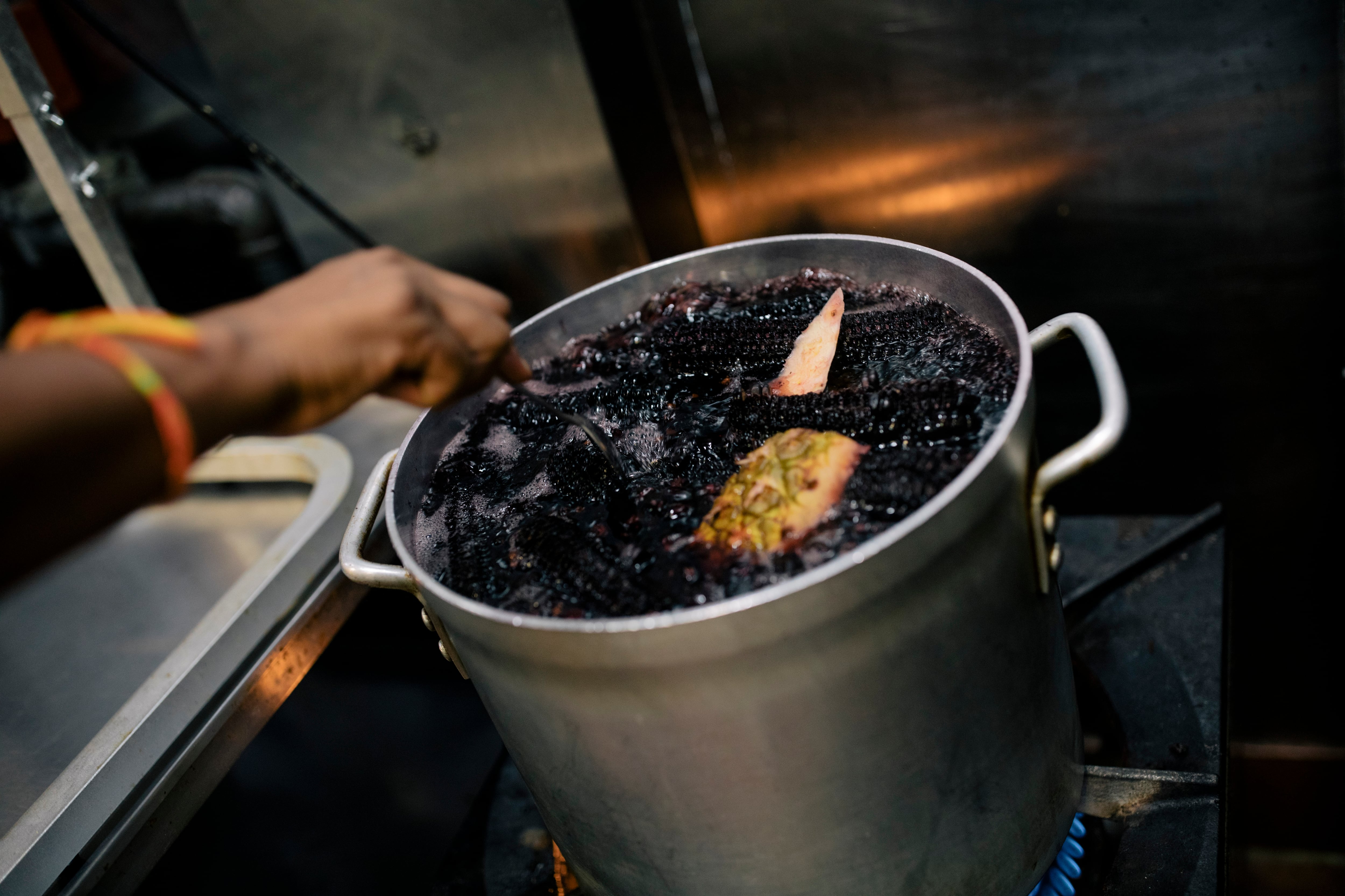 La chicha morada hierve a fuego lento en una olla grande con maíz morado y conchas de piña durante unas dos horas.