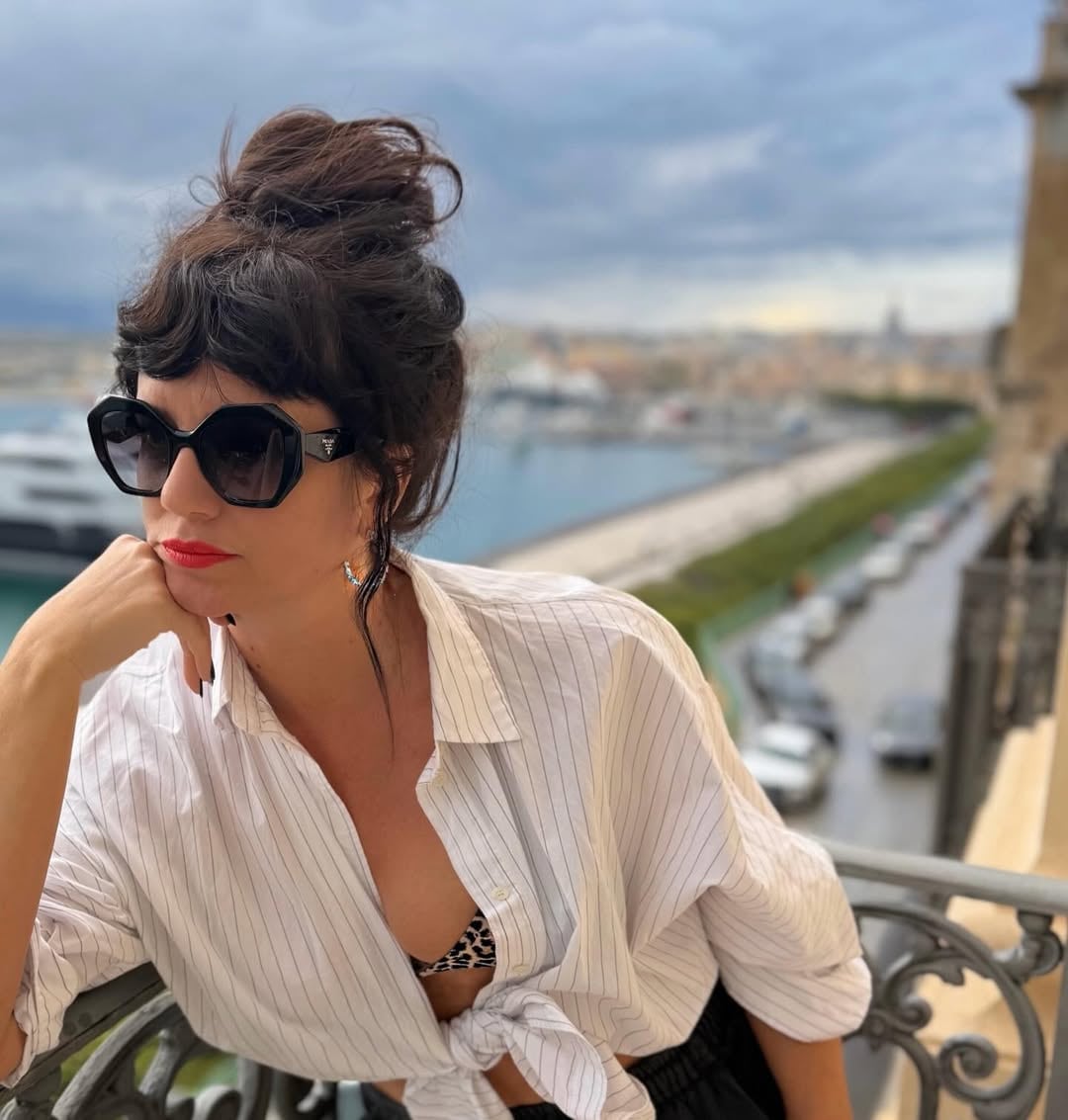 Griselda Siciliani posa con un look relajado en un balcón con vistas al puerto de Sicilia