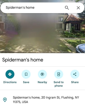 Jack Shi, de 64 años, sonríe en la entrada de su casa en Queens, Nueva York, mientras sostiene varias cartas de niños dirigidas a Spider-Man.