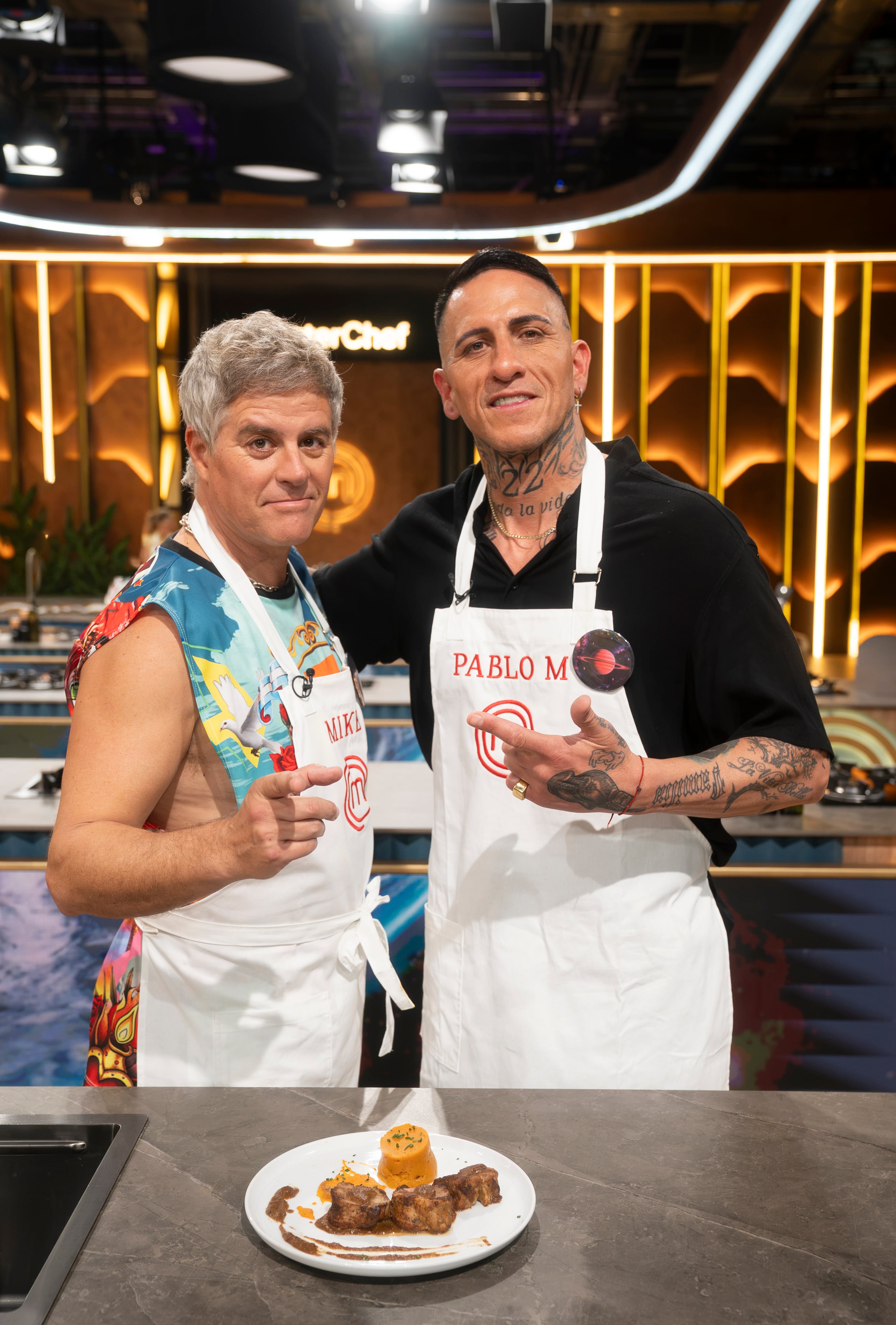 El actor Mike Amigorena y el exfutbolista Pablo Migliore posan junto a su preparación en MasterChef Celebrity