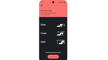 Pantalla de teléfono con una alerta de terremoto de magnitud 6,1 e íconos explicativos de las acciones agacharse, cubrirse y agarrarse